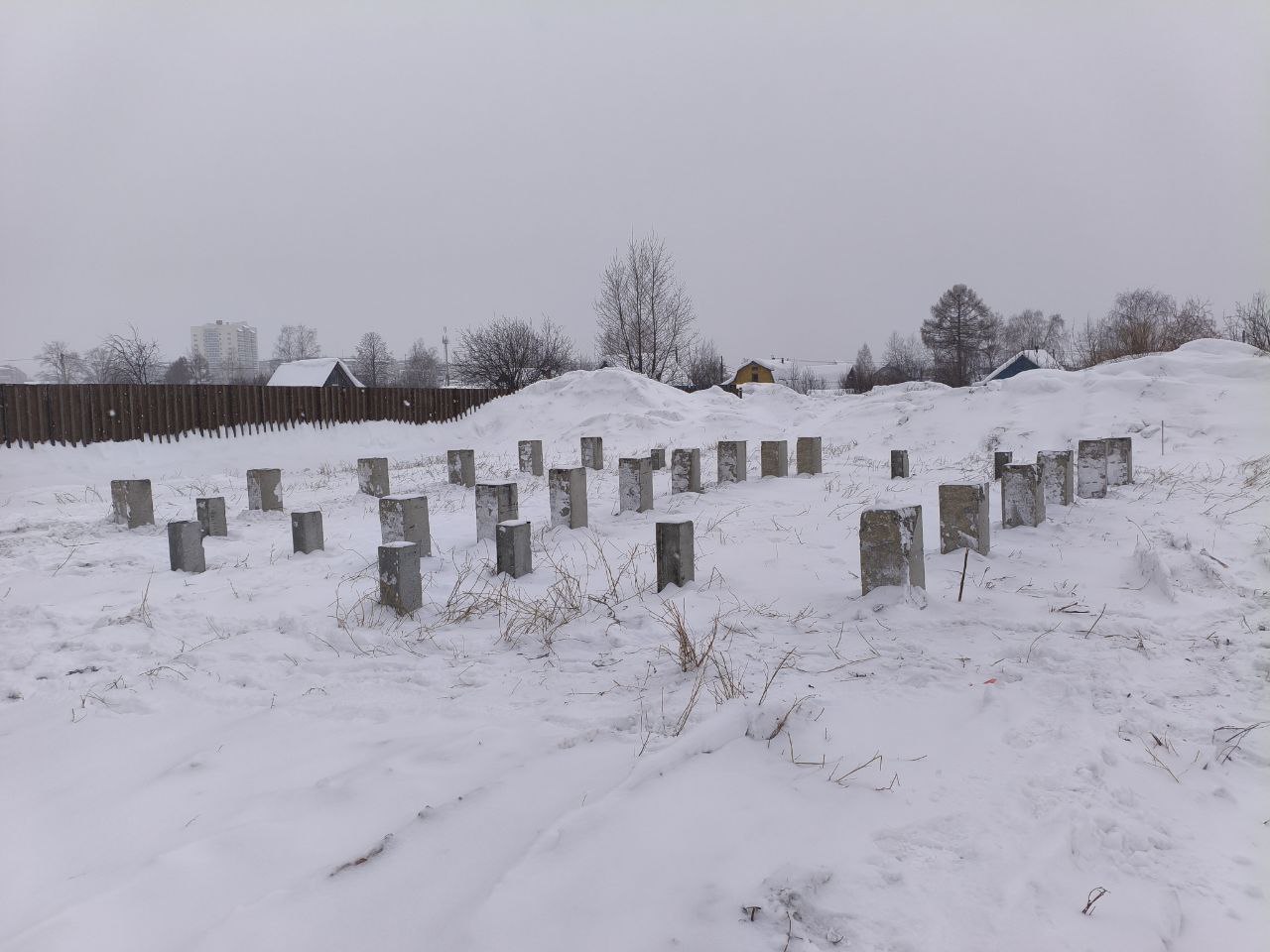 Свайное поле из бетонных столбов под дом зимой, Нижний Тагил, сугробы и следы техники на снегу