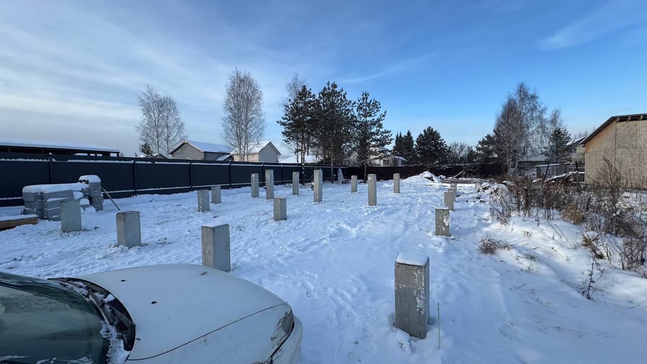 Вид на свайное поле из 19 ЖБ опор для одноэтажного дома среди частной застройки зимой