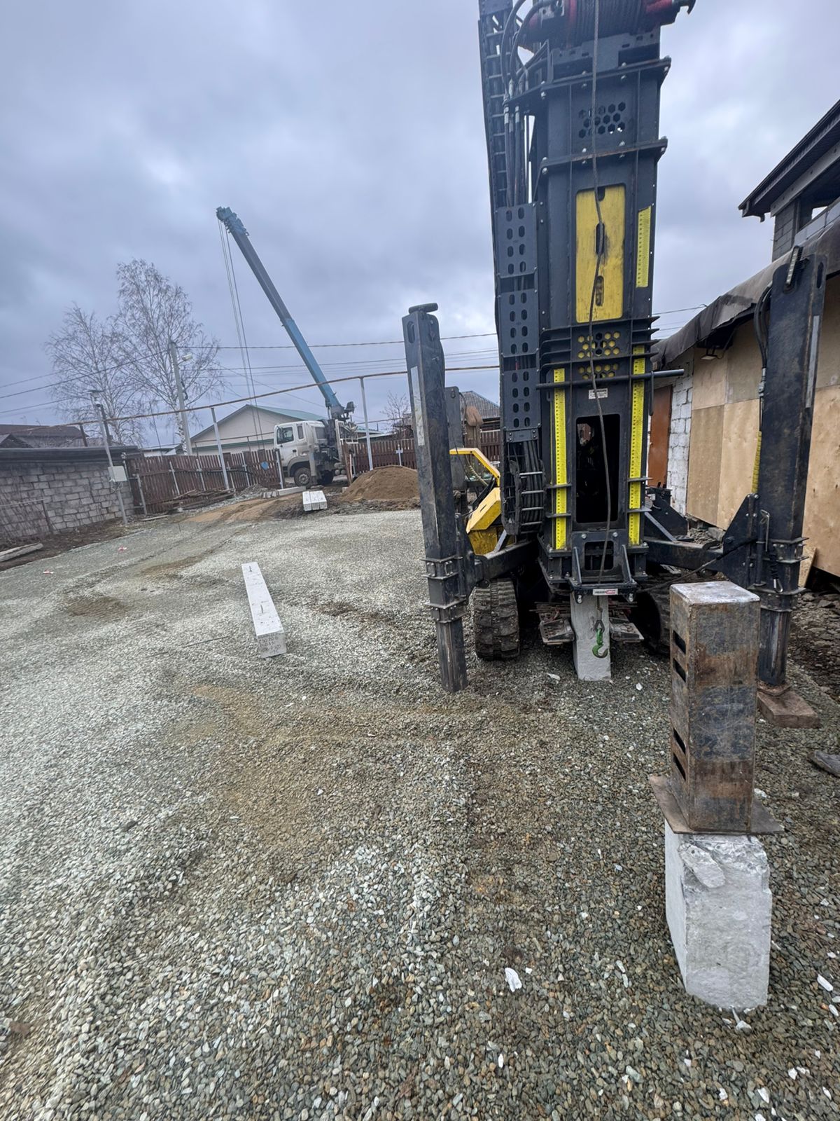 Монтаж свайного фундамента специализированной техникой на стройплощадке в Свердловской области