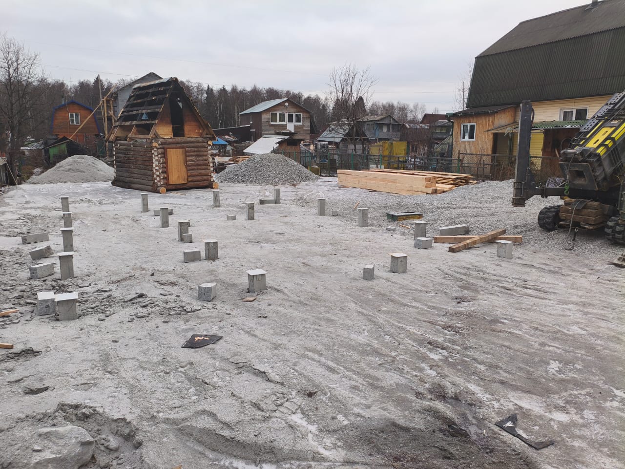 Свайное поле из 18 железобетонных свай под дом из бруса в Среднеуральске, видны металлические оголовки на сваях и щебневая подготовка